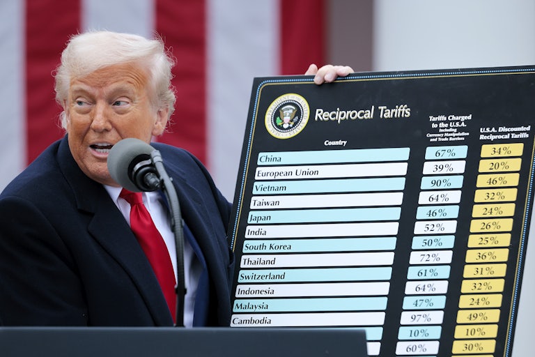Donald Trump holds up a chart while speaking at a podium during a White House Rose Garden press conference on tariffs