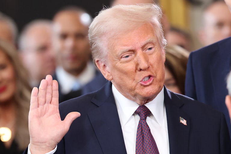 Donald Trump raises a hand as if swearing