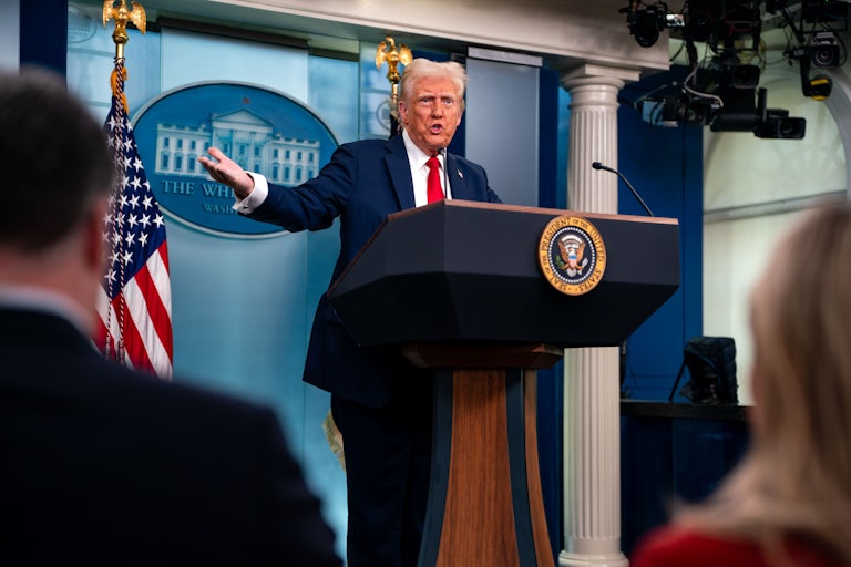 Donald Trump gestures while speaking to reporters