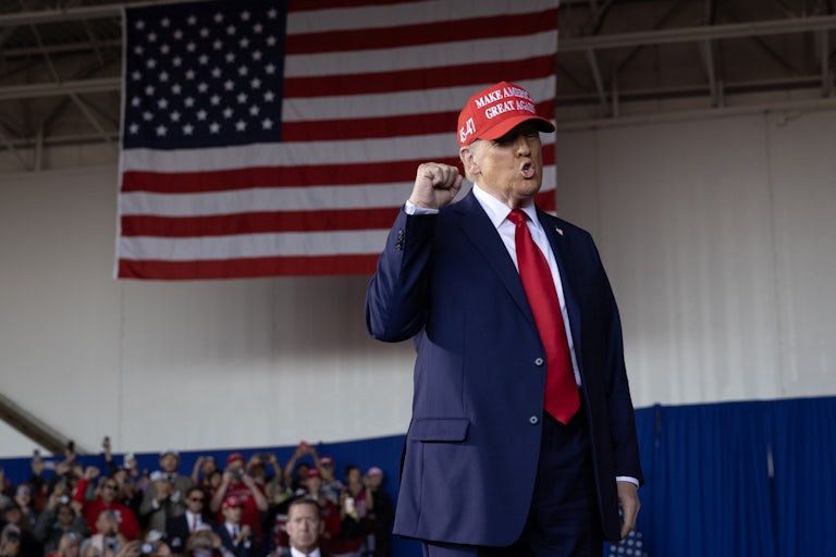Donald Trump raises his fist and speaks at a campaign event