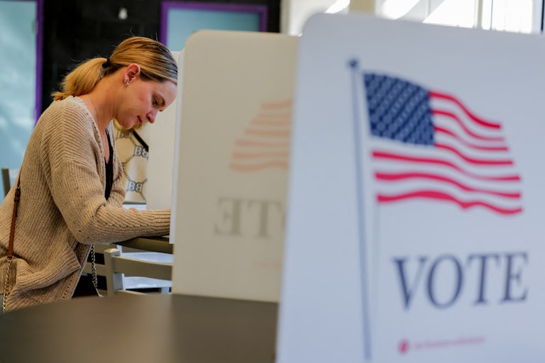 A woman casts her votes at a polling booth