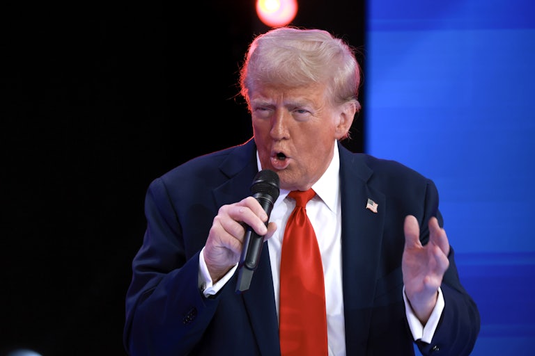 Donald Trump yells into a handheld mic