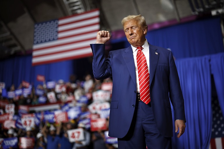 Donald Trump holds up a fist at a campaign rally
