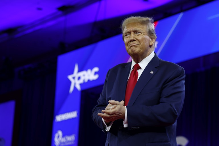 Donald Trump stands with his hands clasped